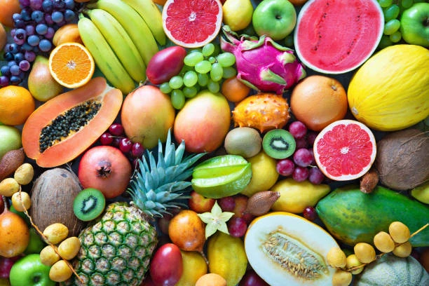 Colorful assortment of fresh tropical fruits, including pineapple, papaya and dragon fruit