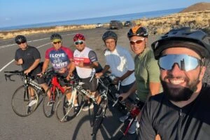 Men from the church bike ministry with their road bikes on a coastal road beside a lava field