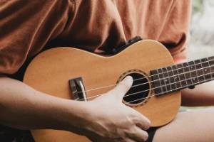 Hands playing a ukulele during worship